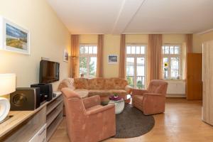 奥斯赛拜-屈隆斯博恩Residenz-Ostseewind-Wohnung-16-280的客厅配有沙发、椅子和电视