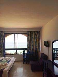 苏塞布杰法住宅酒店的酒店客房设有一张床和一个享有海景的窗户。