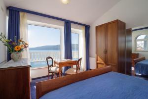 希杰弗朗吉卡麦迪特拉纳别墅酒店的配有一张床、一张书桌和一扇窗户的酒店客房