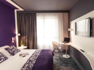 永河畔拉罗什永河畔拉罗什中心美居酒店的酒店客房设有床和窗户。