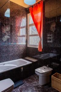 弗龙特拉APARTMENTS ON AN ORGANIC FARM BY THE COAST, Frontera的带浴缸、卫生间和窗户的浴室