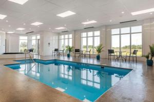 蒙若利Quality Inn & Suites Mont-Joli的一个带桌椅的房间的游泳池