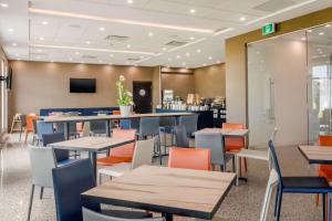 蒙若利Quality Inn & Suites Mont-Joli的一间带桌椅和电视的餐厅