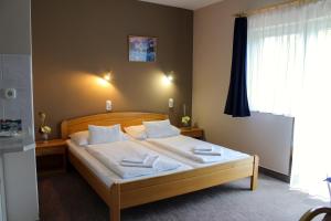 哈卡尼Lídia Hotel的一间卧室配有带白色床单和枕头的床。