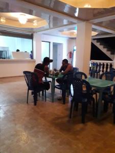 圣卡塔利娜岛Oceans Hostal的两人坐在餐厅桌子旁