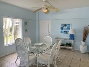 西耶斯塔岛Island House Beach Resort 5S的一间设有玻璃桌和白色椅子的用餐室