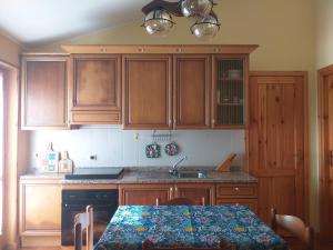 桑格罗堡Luminoso trilocale finemente arredato的厨房配有木制橱柜、桌子和水槽。