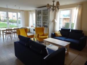 奥斯坦德Bootsman gelijkvloers appartement met tuin en autostaanplaats的客厅配有蓝色的沙发和黄色的椅子