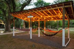 林多亚VILLA DO SOSSEGO pousada的公园内木制凉亭下的吊床