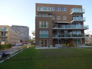 奥斯坦德Bootsman gelijkvloers appartement met tuin en autostaanplaats的公寓大楼前面设有草坪