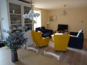 奥斯坦德Bootsman gelijkvloers appartement met tuin en autostaanplaats的客厅配有黄色椅子和沙发