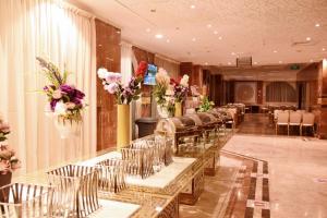 麦地那Al Andalus Palace 1 Hotel的鲜花盛开的房间里一排桌椅