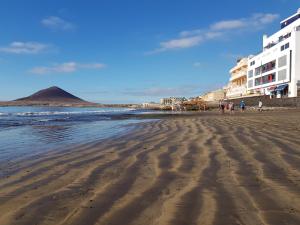 厄尔梅达诺Alquilaencanarias-Medano, Cabezo beach & pool的沙滩上的人在沙滩上散步