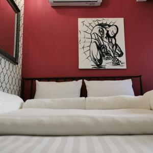 尼什Different Apartments的卧室配有红色墙壁和摩托车绘画