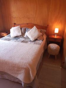 科金博Hostal Playa Peñuelas的一间卧室配有带枕头和椅子的床
