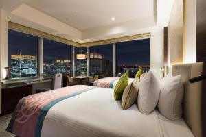 东京东京丸之内大都会酒店的一间带一张大床的卧室,享有城市景观