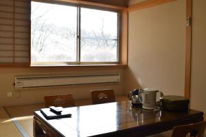 TōnoTakamuro Suikoen的一间带桌子和窗户的用餐室