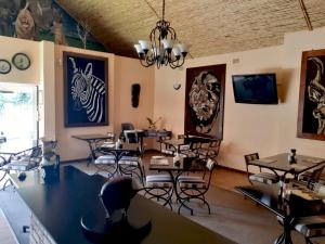 米德兰Ipe Tombe Guest Lodge - Midrand的一间带桌椅和吊灯的用餐室