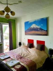 科隆科隆住宿酒店的卧室配有一张挂有山壁画的床