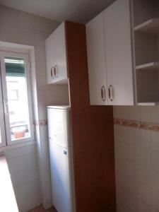 马德里M17 Madrid Centro apartamento con wifi的厨房配有白色冰箱和窗户。