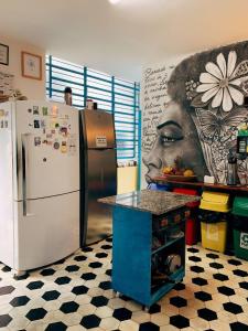 累西腓Zili Pernambuco - Hostel Pousada的带冰箱的厨房和妇女画