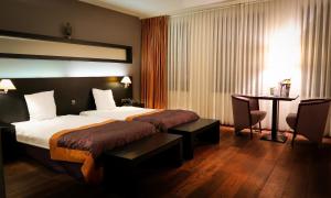 马塞克范艾克酒店的酒店客房配有一张床铺、一张桌子和一张书桌。
