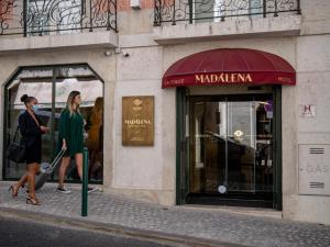 里斯本Madalena by The Beautique Hotels的两个女人在商店前的街上走