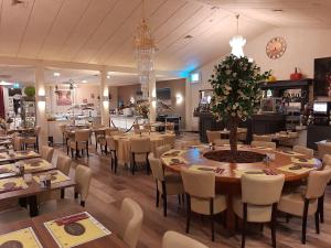 阿尔登堡Hotel De Elderschans的一间餐厅,配有桌椅和圣诞树