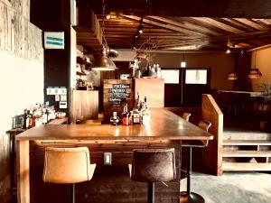 箱根RoheN Resort&Lounge HAKONE的酒吧设有一张大木桌和椅子