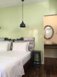 博卡斯德尔托罗RIVA B&B的卧室配有一张白色大床和镜子