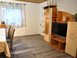 SalzwegDahoam的客厅配有平面电视和书桌。