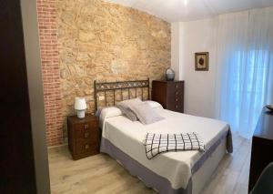 菲尼斯特雷CASA SAN JURJO的一间卧室设有一张床和砖墙