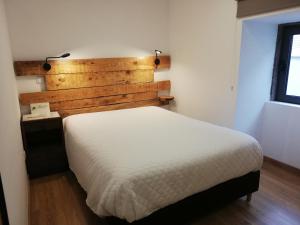 萨布盖鲁Sambuc'asa - Serra da Estrela的卧室配有白色的床和木制床头板
