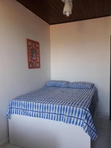 波托德索比Village em Porto de Sauípe - Lazer e natureza的一张带蓝色和白色条纹棉被的床