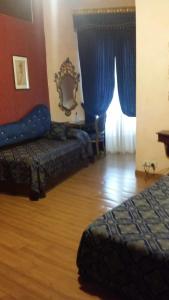 佛罗伦萨阿巴克酒店的一间卧室设有两张床,窗户配有蓝色窗帘