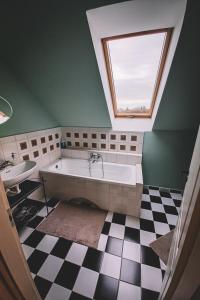 GödPannónia Apartment的一间带大浴缸和窗户的浴室