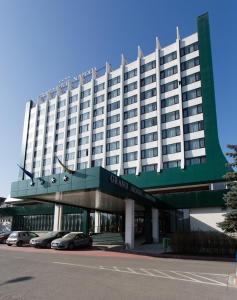 克卢日-纳波卡纳波卡大酒店的大型酒店门前设有停车场