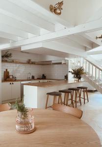 塔南达The Loft - beautiful central Barossa apartment的厨房配有木桌和一些椅子