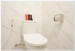Kalibanteng-lorRedDoorz Plus @ Madukoro Raya Semarang的浴室设有白色的卫生间和白色的墙壁