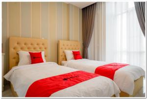 Kalibanteng-lorRedDoorz Plus @ Madukoro Raya Semarang的客房内的两张床和红色枕头