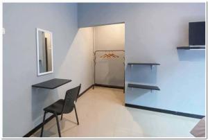 DaresRedDoorz Syariah near T2 Juanda Airport 2的客房设有桌子、椅子和冰箱。