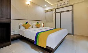 钦奈Itsy By Treebo - Deluxe Inn的一间卧室配有一张大床和色彩缤纷的毯子