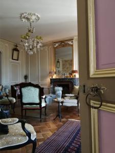贝叶Hôtel particulier "le clos de la croix"的客厅配有椅子和吊灯。