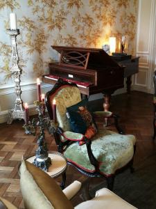 贝叶Hôtel particulier "le clos de la croix"的客厅配有钢琴和椅子