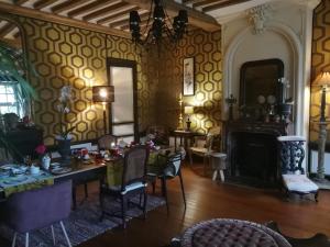贝叶Hôtel particulier "le clos de la croix"的客厅配有桌椅和壁炉