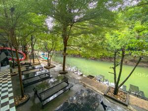班康卡臣Natthapon Resort Kaeng Kachan的河旁公园里的一群长椅