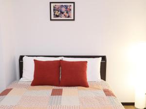 Chikusachōケイアイコンホテルズ 池下的一间卧室配有一张带两个红色枕头的床