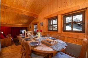 夏蒙尼-勃朗峰Le Chalet au Tour ski in-ski out - Happy Rentals的木制用餐室配有桌椅