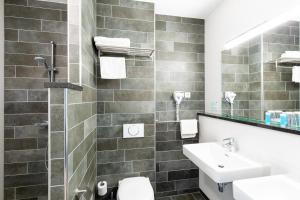 吕伐登巴斯通吕伐登酒店的一间带水槽、卫生间和镜子的浴室