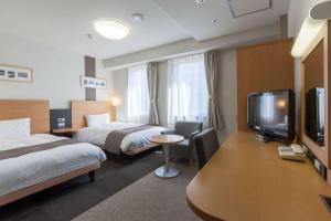 广岛广岛大手町康福酒店的酒店客房设有两张床和一台平面电视。